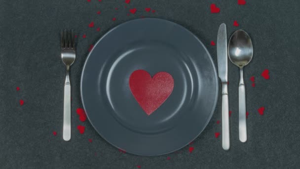 Vörös szív egy szürke tányéron. Fekete háttér. Valentin Szerelem kártya. Mi van a tányérodon? Szeretet! Gyönyörű Szent Valentin-napi kártya. Szép másolási hely.. - Felvétel, videó