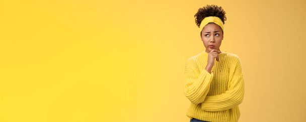 Вы не уверены, обеспокоенный милый африканско-американская девушка сталкивается жесткое решение посмотреть вдумчивый план, думая, как действовать право касания подбородок, сделать предположение стоя обеспокоенный желтый фон. - Фото, изображение