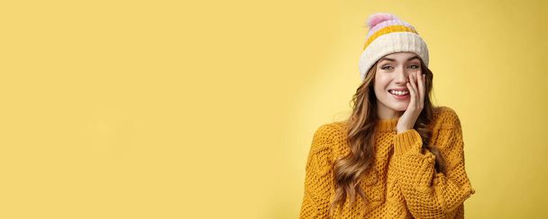 Smiling attractive carefree young 20s woman having fun talking casually nice conversation girlfriend press palm cheek amused blushing receive flirty compliment, standing positive yellow background. - Photo, Image