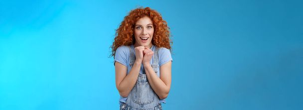 Lifestyle. Tender silly sensitive redhead emotive curly girl clench hands together touched smiling gasping see heartwarming scene lovely puppy look camera fascinated delighted gaze impressed blue - Photo, Image