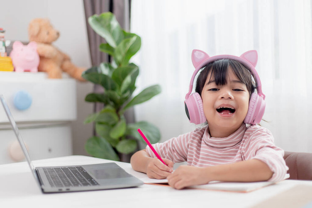 Menina asiática em fones de ouvido tem chamada de vídeo aula distante com professor usando laptop, estudar on-line no computador, conceito de ensino em casa - Foto, Imagem