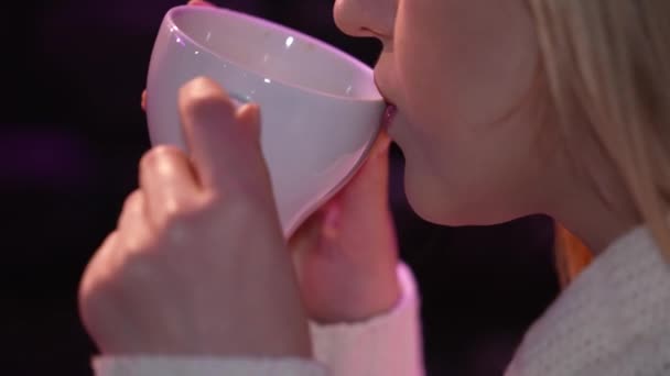 The girl drinks coffee, fresh espresso in a white cup. Hands and lips are close-up, the face is not visible. A conversation in a coffee shop, a friendly meeting, a date. - Video, Çekim
