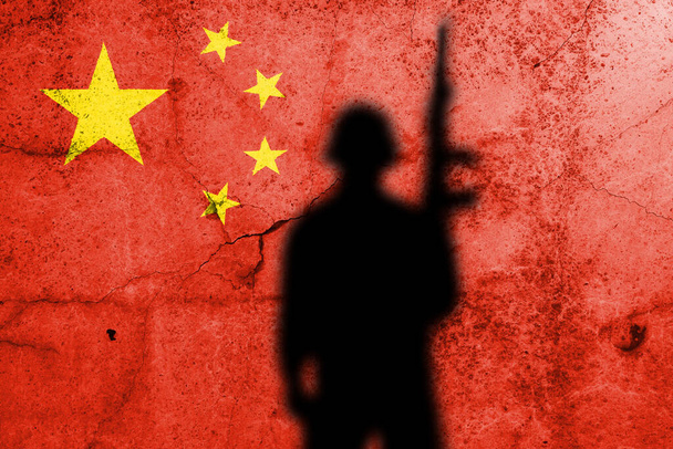 Σημαία της Κίνας ζωγραφισμένη σε τσιμεντένιο τοίχο με σκιά στρατιώτη - Φωτογραφία, εικόνα