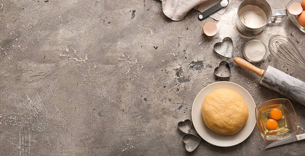 Υλικά και σκεύη για την προετοιμασία νόστιμων μπισκότων σε σχήμα καρδιάς σε φόντο grunge με χώρο για κείμενο. Γιορτή του Αγίου Βαλεντίνου - Φωτογραφία, εικόνα