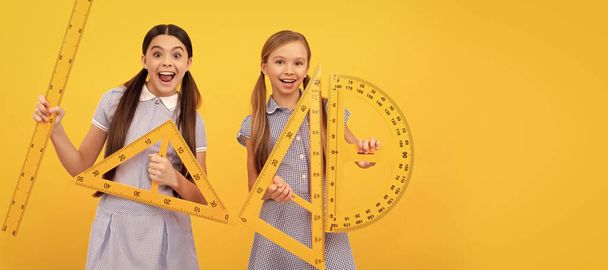 School girls friends. Happy teen girls hold geometric tools. School education. Learn and grow together. Banner of school girl student. Schoolgirl pupil portrait with copy space - 写真・画像