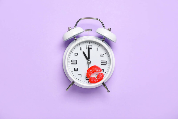 Vintage alarm clock with lipstick kiss mark on lilac background - Zdjęcie, obraz