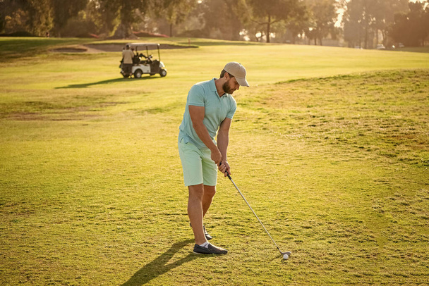 people lifestyle. professional man playing game on green grass. summer activity. professional sport outdoor. male golf player on professional golf course. portrait of golfer in cap with golf club. - Photo, Image