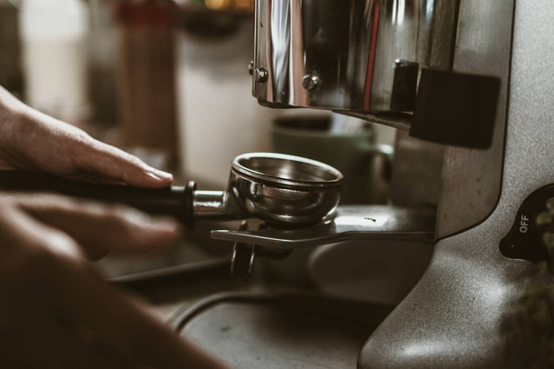 barista use bottomless filter with grinder machine at coffee shop. coffee maker concept. - 写真・画像