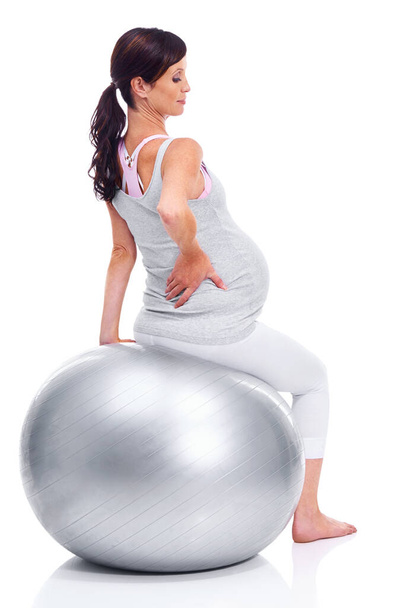 Making sure her back is supported. A pregnant mother sitting on a pilates ball - Fotó, kép