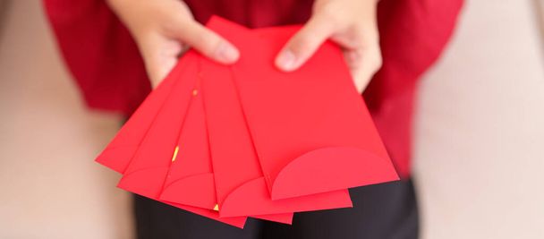 Woman holding Chinese red envelope, money gift for happy Lunar New Year holiday - Zdjęcie, obraz