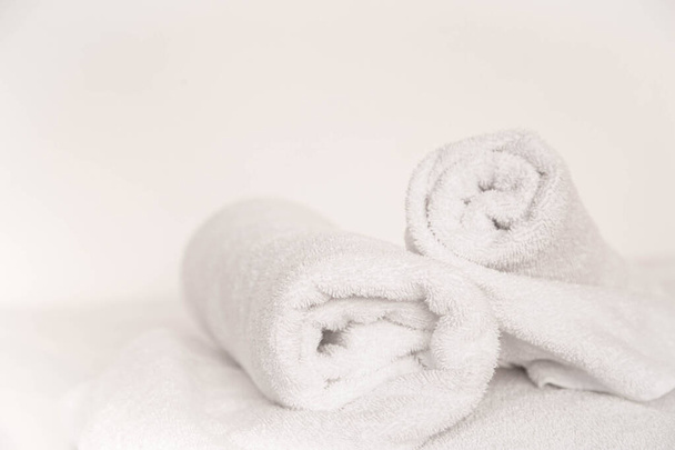 A spa composition with a white towels on a white background, copy space. - Foto, afbeelding