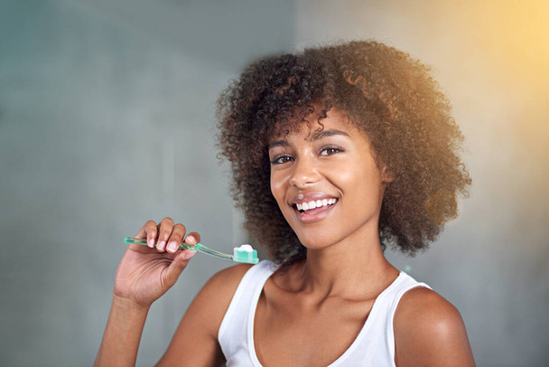I brush three times per day. Cropped portrait of a young woman brushing her teeth in the bathroom - Foto, Imagem