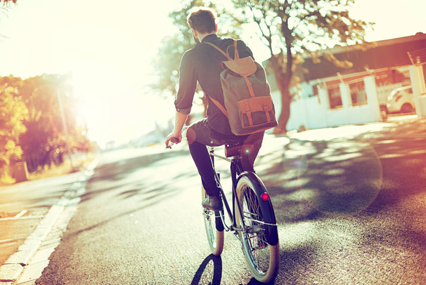 Беззаботный и без углерода. Фотография молодого человека, катающегося на велосипеде на открытом воздухе - Фото, изображение