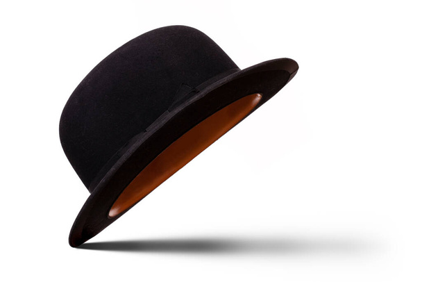 Черный шляпа котелок наклонен, чтобы увидеть под ним с тенью изолированы на белом фоне - Фото, изображение