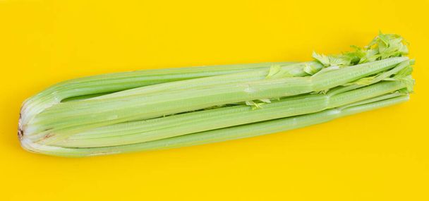Fresh celery on yellow background. - Valokuva, kuva
