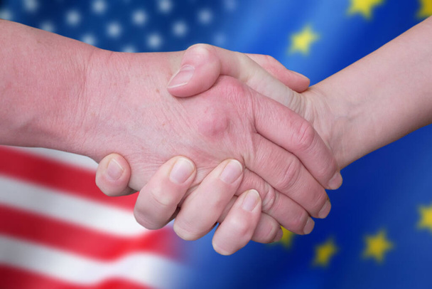 Handshake and European Union and United States flags, blue european union EU flag and half usa united states of america flag, concept, closeup - Fotografie, Obrázek