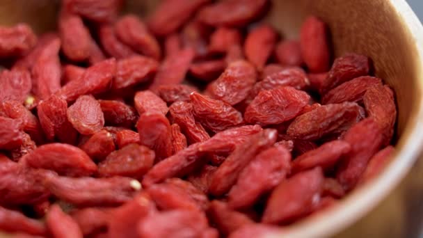 Dried red wolfberries (goji berry) in wooden rustic bowl close up. Rotation - Filmagem, Vídeo
