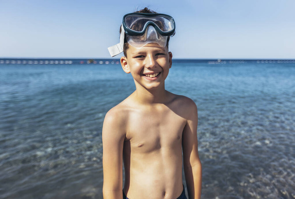 Portret uśmiechniętego chłopca w masce nurkowej nad morzem - Zdjęcie, obraz