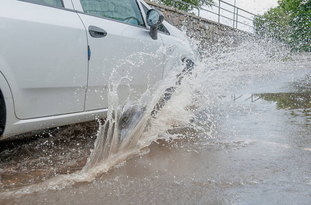 浸水した道路を走行する車 - 写真・画像