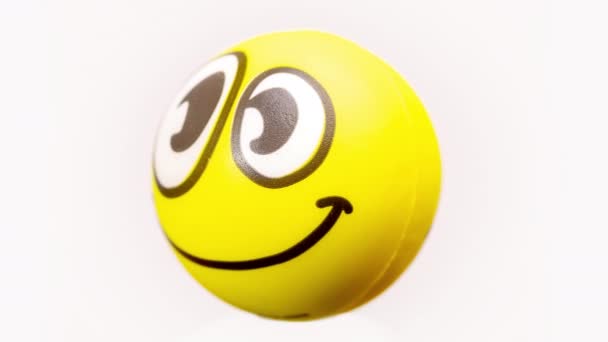 a soft ball with smiley emoji face turning - Záběry, video