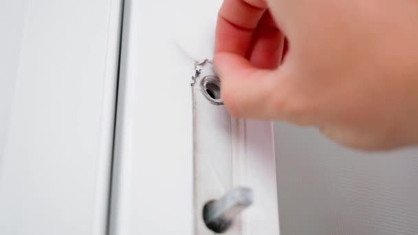 A hand rips off a protective film from a plastic door close-up. Installation of interior white plastic doors. High quality 4k footage - Materiał filmowy, wideo