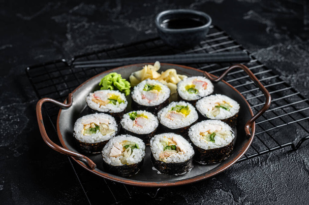 Kimbap gimbap filled with vegetables, egg, eanchovy and crab, Korean rice roll. Black background. Top view. - Foto, Imagen