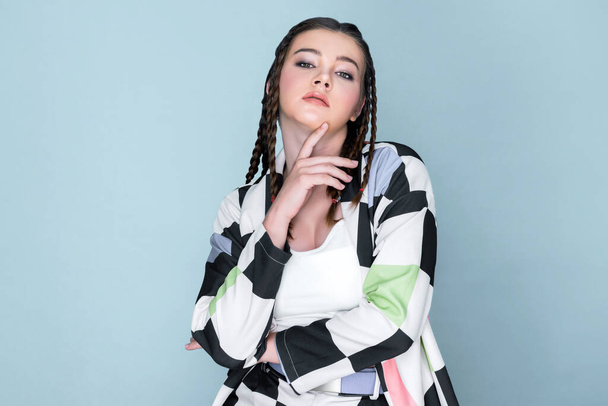 Closeup beautiful young girl with perfect skin, cosmetic and long braid posing with trendy fashion outfit in the studio with isolated background. charming young teenage with beauty gesture. - Φωτογραφία, εικόνα