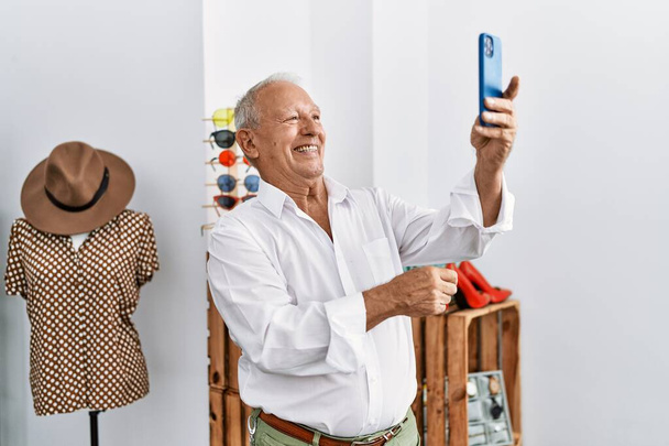 Hombre mayor cliente haciendo selfie por el teléfono inteligente en la tienda de ropa - Foto, imagen