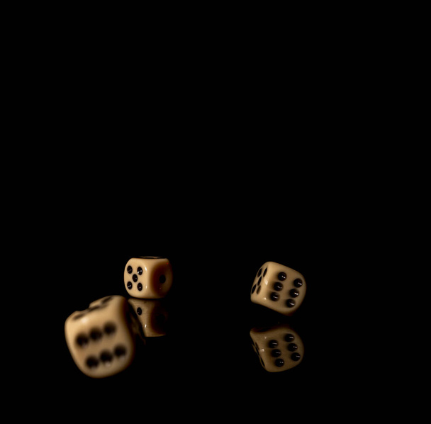 Желтые кубики игры на блестящем черном столе с темным отражением - Фото, изображение