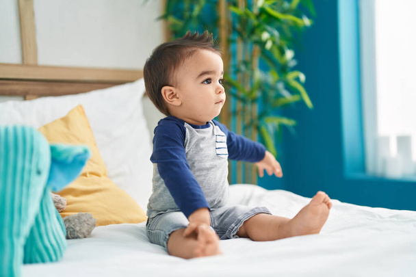 Sevimli İspanyol bebek yatak odasında oturuyor. - Fotoğraf, Görsel