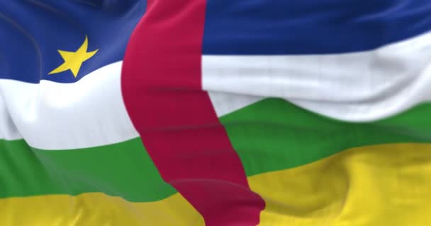 Orta Afrika Cumhuriyeti 'nin rüzgarda dalgalanan ulusal bayrağının yakın çekimi. Dalgalı kumaş. Seçici odaklanma. Gerçekçi 3D canlandırma. Yavaş çekim döngüsü - Video, Çekim