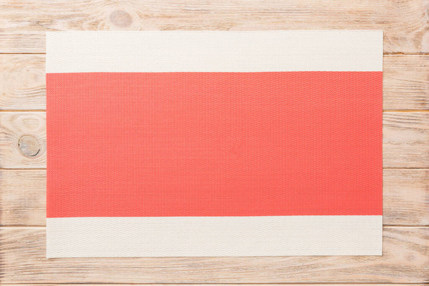 Top view of red tablecloth for food on wooden background. Empty space for your design. - Photo, Image