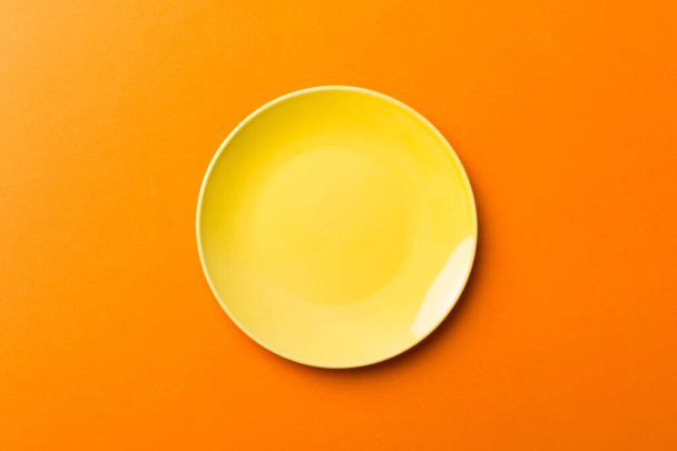 Vista superior do isolado de fundo colorido vazio rodada placa amarela para alimentos. Prato vazio com espaço para o seu design. - Foto, Imagem