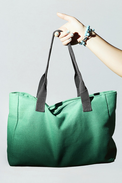 Textile handbag in beautiful woman hand. fashion green sport bag - Photo, Image