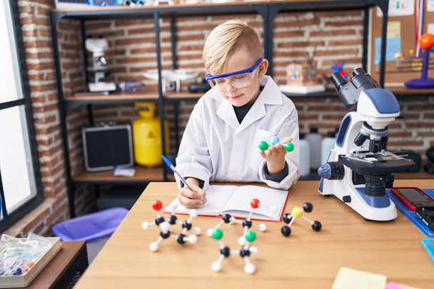Suloinen lapsi opiskelija kirjallisesti kannettavan tilalla molekyyli luokkahuoneessa - Valokuva, kuva