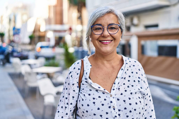 Frau mittleren Alters lächelt selbstbewusst auf der Straße - Foto, Bild