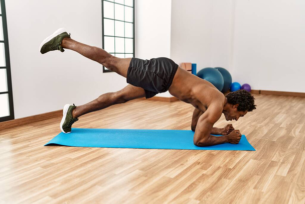 Young african american man training abs exercise at gym - Foto, Bild