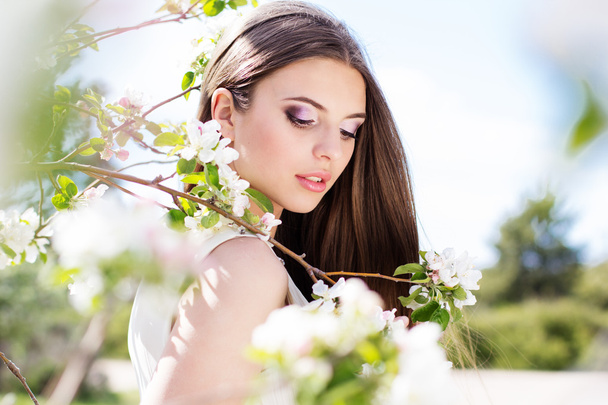 Beautiful girl in a cherry blossom garden - Foto, immagini
