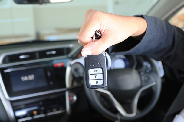 Biznes kobieta Pokaż zdalne klucz w nowoczesny pojazd samochodowy. - Zdjęcie, obraz