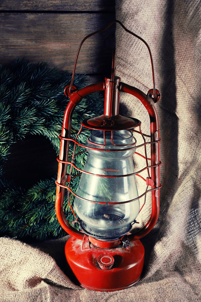 Kerosene lamp with wreath on wooden planks background - Fotó, kép