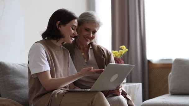 uma filha adulta explica a uma mãe idosa de cabelos grisalhos como usar gadgets modernos e como trabalhar em um laptop. - Filmagem, Vídeo