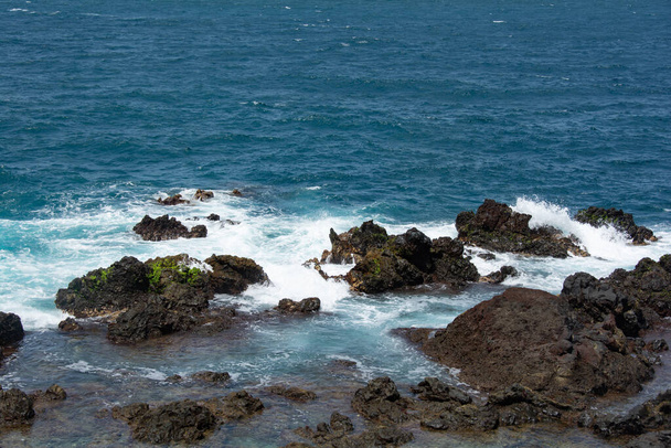 Rocks in the breakers on the coast of the Canary Island of Tenerife, Spain - Fotó, kép