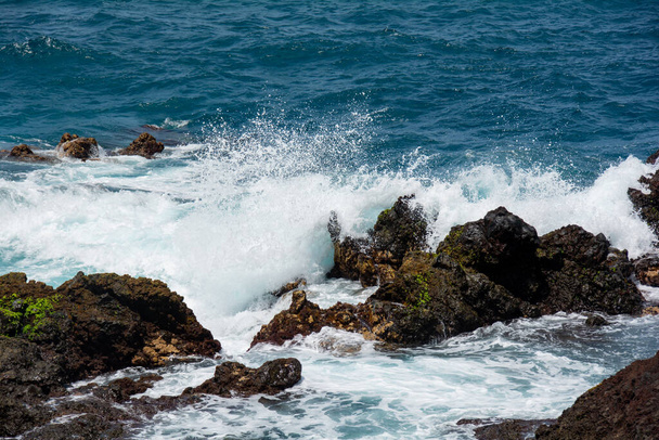Rocks in the breakers on the coast of the Canary Island of Tenerife, Spain - Fotó, kép