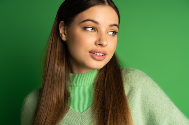 Portrait of pretty teen girl in jumper standing on green background  - Фото, зображення