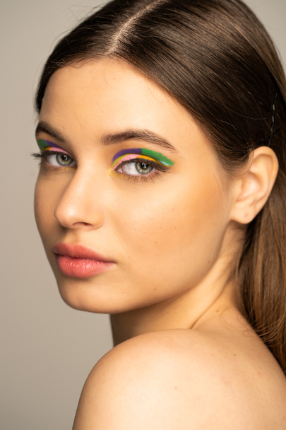 Portrait of teen model with colorful makeup isolated on grey  - Fotografie, Obrázek