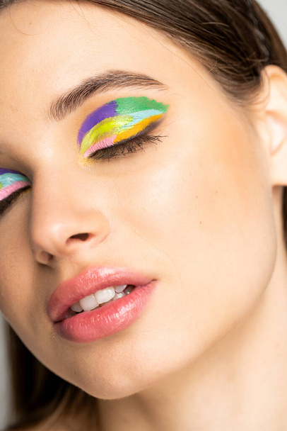 close up view of teenage model with colorful eyeshadows and closed eyes  - Fotoğraf, Görsel