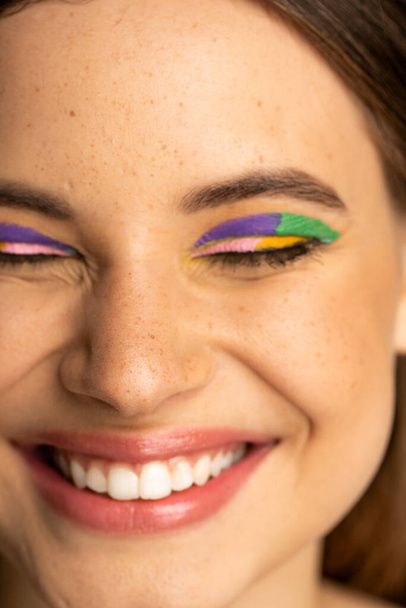 Close up view of cheerful teen girl with colorful visage closing eyes - Foto, afbeelding