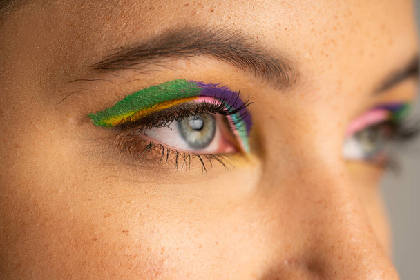 Cropped view of teen girl with freckles and colorful eyeshadows isolated on grey  - Fotó, kép