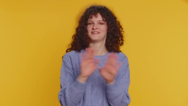 I am dont want it, not me. Confused displeased young teen woman in sweater pointing fingers herself, rejection, refusal stop failure sign. Pretty curly haired girl isolated on yellow studio background - Filmati, video