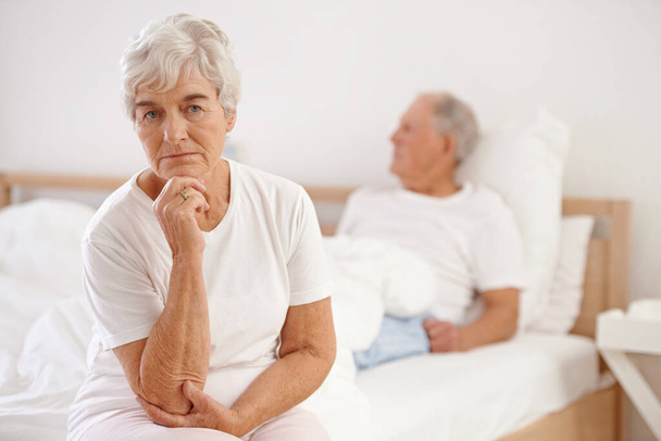 Arguments are a part of any relationship. a elderly couple looking unhappy in their bedroom - Foto, Bild